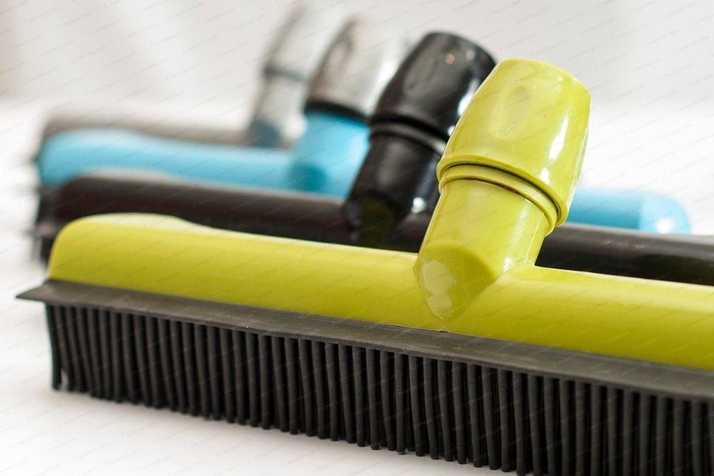 Four Sweepa® natural rubber brooms in a row, their rubber bristles facing down