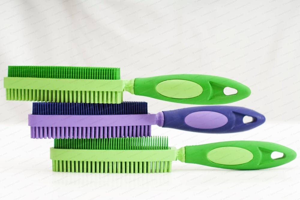 Three natural rubber lint brushes stacked on a white surface